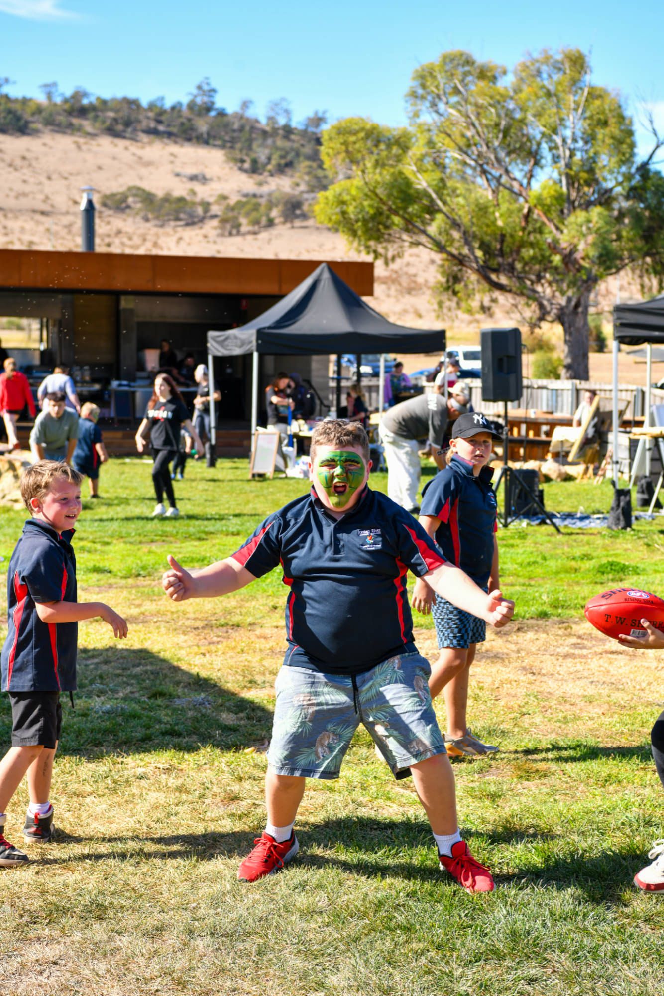 Kids playing football at Bond place with face paint on
