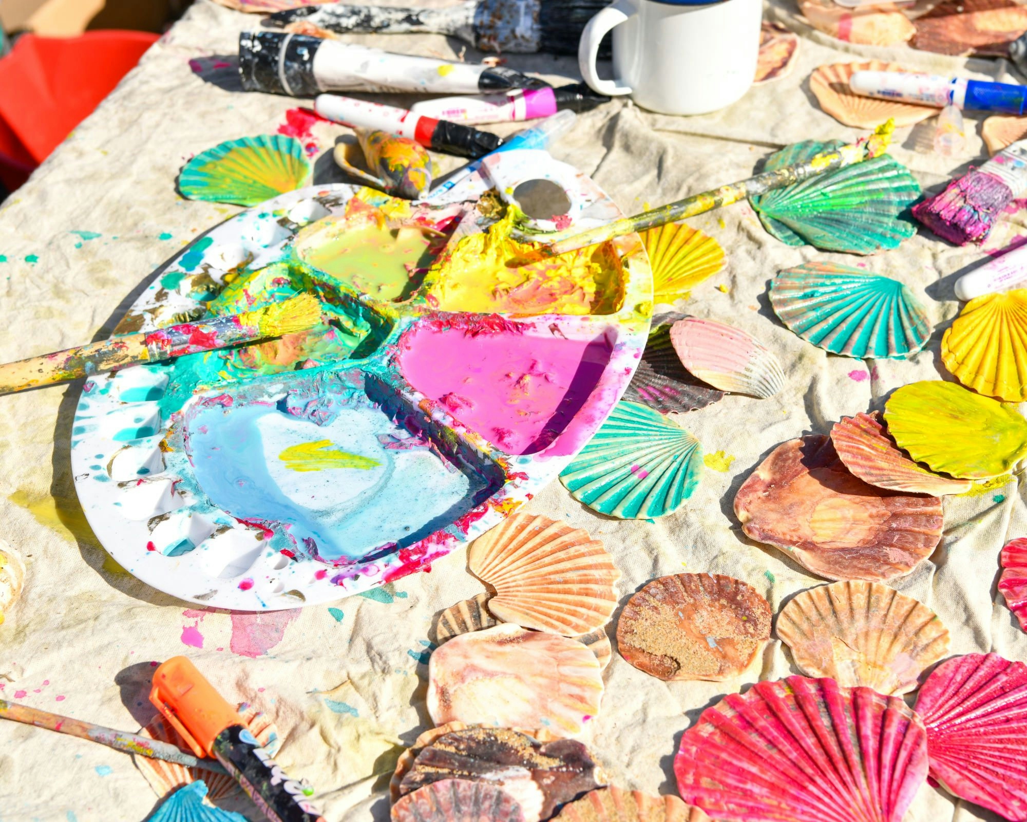 A table filled with colourful shells and paint
